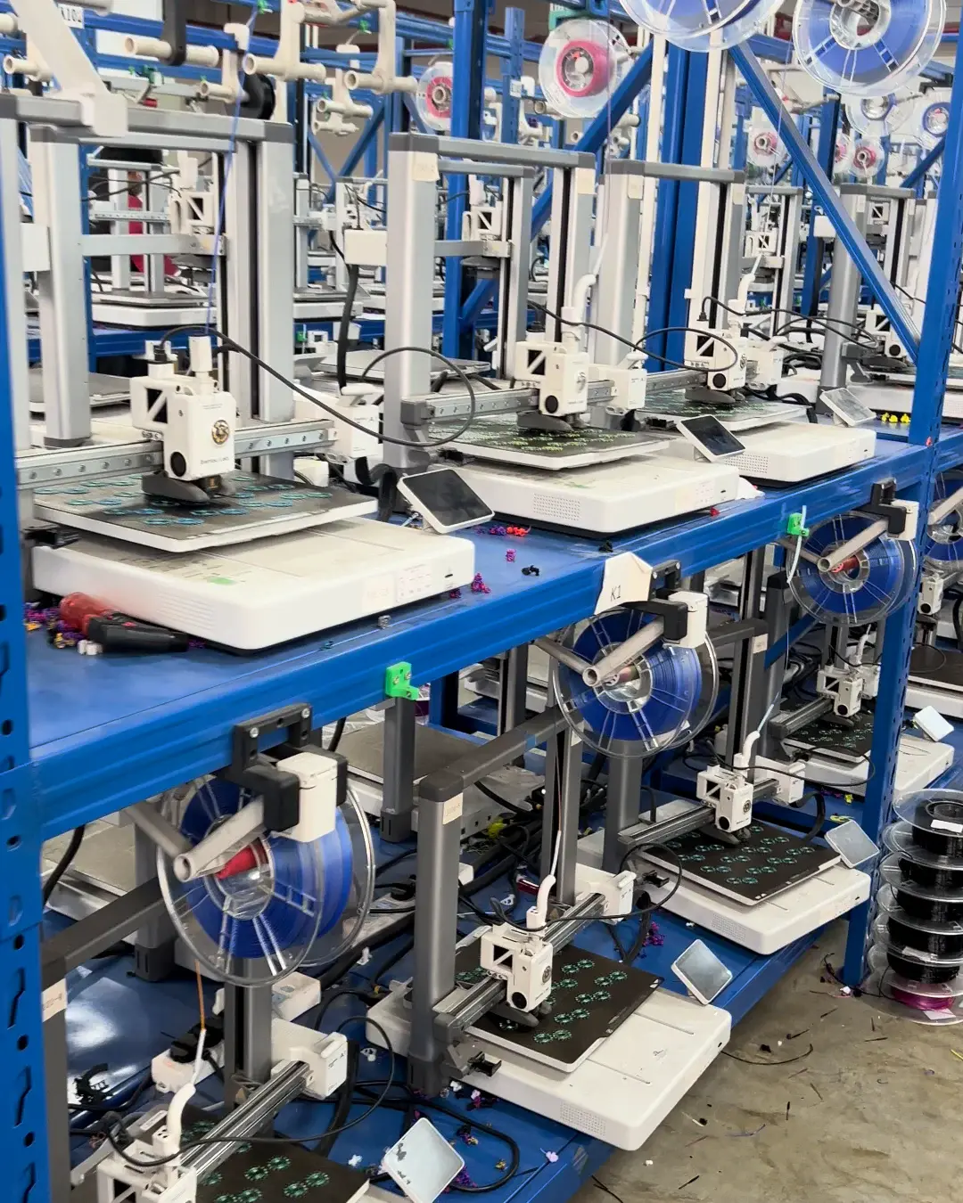 Rows of open-frame FDM printers installed on production racks